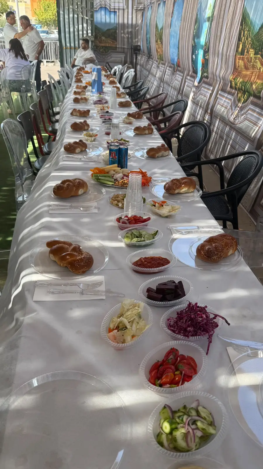 שולחן ארוך ערוך עם חלות וסלטים